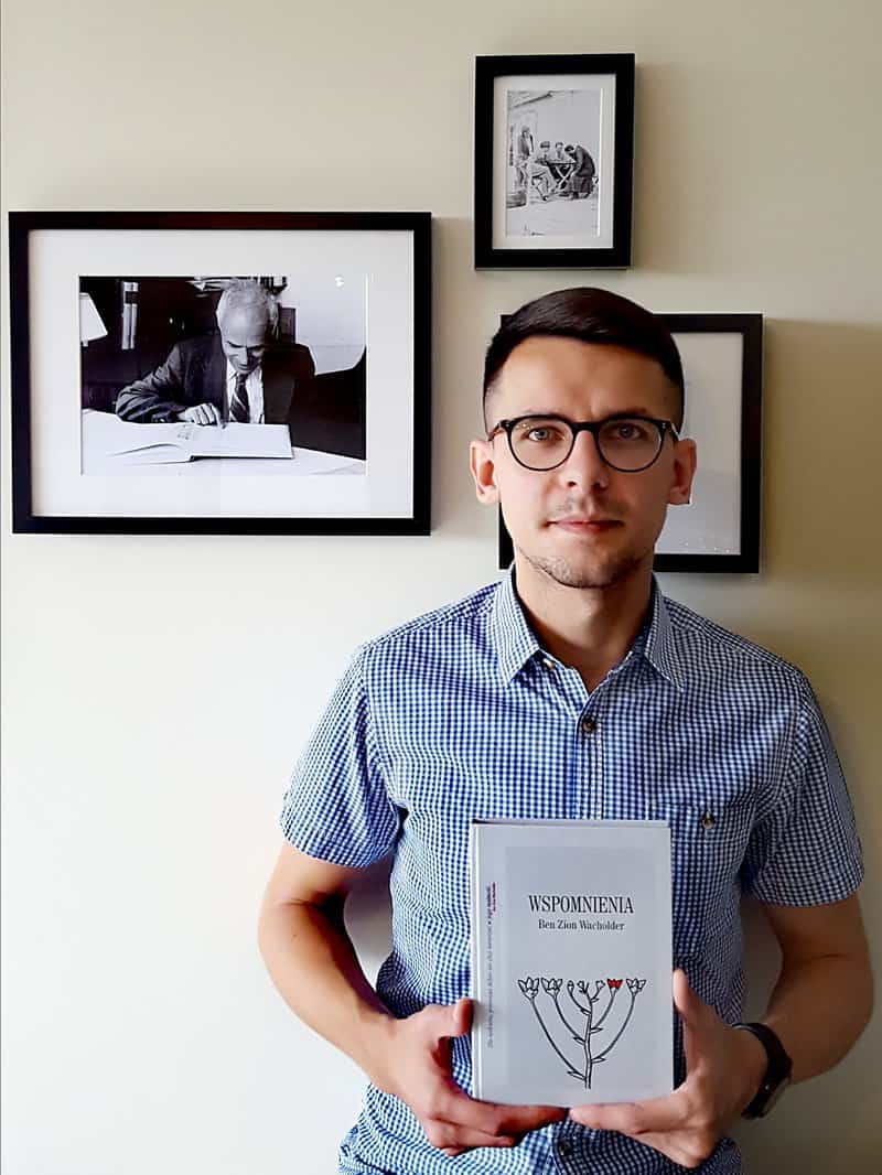 Lukasz Rzepka holds the Polish translation of my father Ben Zion Wacholder's Memories: Wspomnienia. My father's picture is hanging in the background.