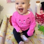 smiley sitting baby in pink shirt