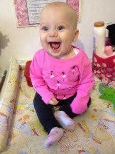 smiley sitting baby in pink shirt