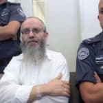 Ezra Sheinberg in court, flanked by police officers