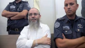 Ezra Sheinberg in court, flanked by police officers